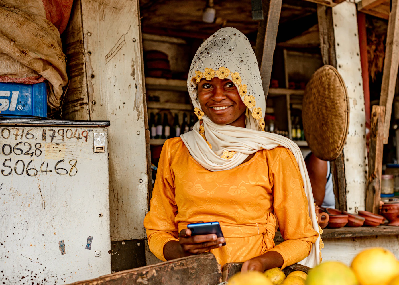 A trader at her market stall checking orders on her phone